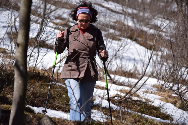 kobieta z kijami na sniegu uprawiająca Nordic Walking