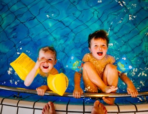 szczęśliwi rozesmiani chłopcy w basenie