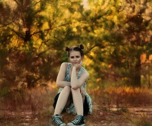 zamyslona dziewczyna siedząca w lesie