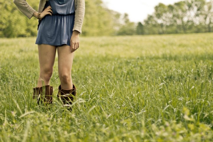 dziewczyna stojąca w wysokiej trawie