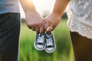 małżeństwo wspólnie niosące buciki dla dziecka